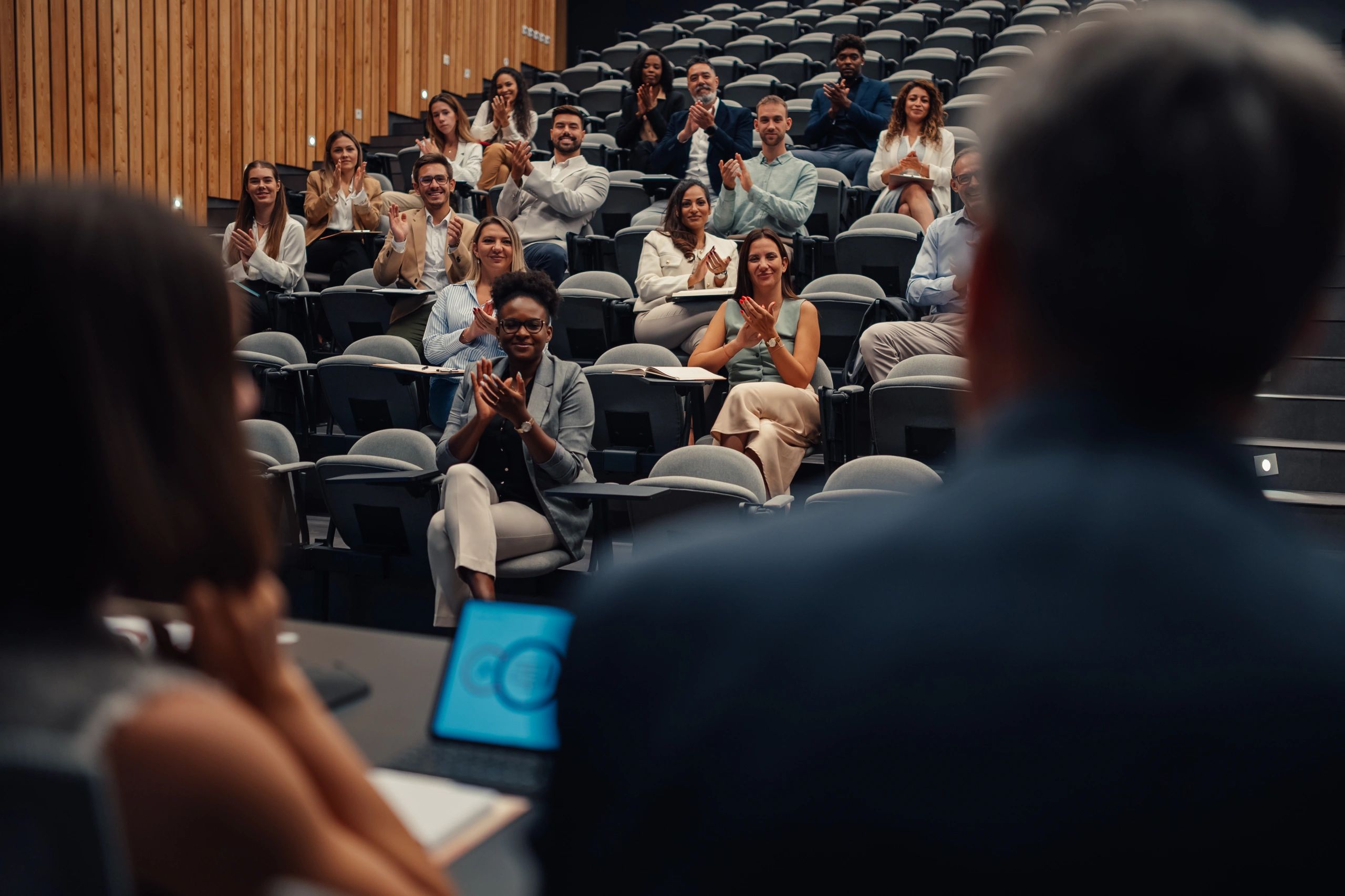 Audience applauding at a conference presentation